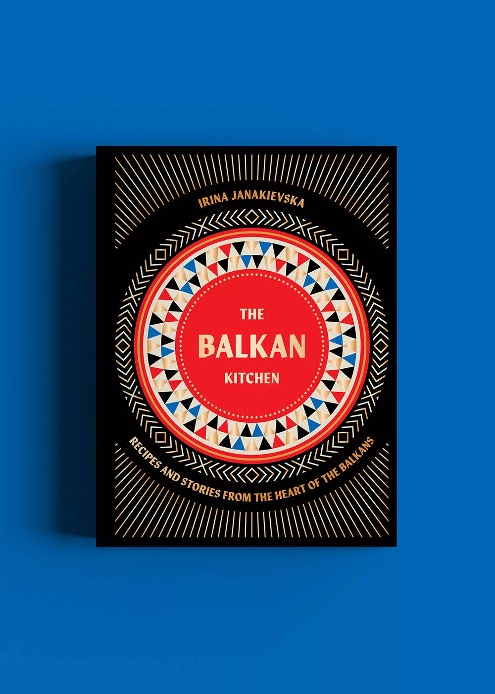 Das Buch The Balkan Kitchen von Irina Janakievska vor blauem Hintergrund